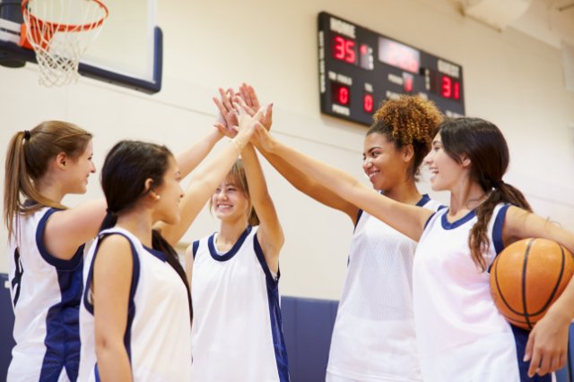 Group of girls high fives basketball
